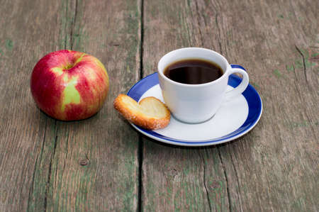coffee on a saucer, cookies and one apple, on a wooden table, a subject food and drinksの写真素材