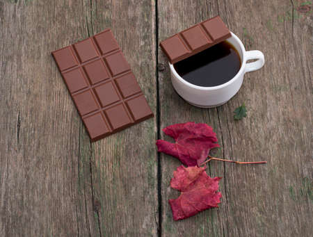 coffee, a piece of chocolate on a cup, nearby chocolate and a red leaf, on a wooden table, the top view, fall, a still life a subject drinksの写真素材