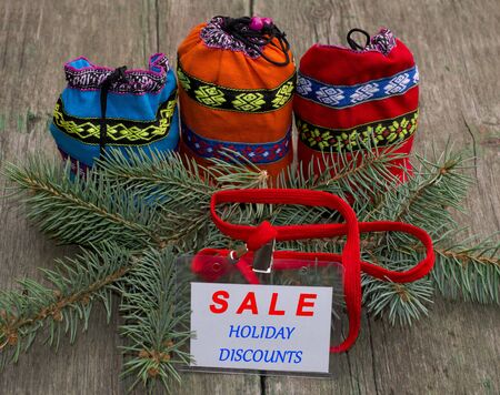 fir-tree branch, three bags with gifts and a label Festive Christmas Sale, on a wooden table, a subject holidays Christmas and New Yearの写真素材