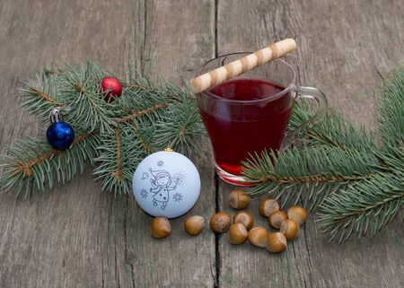 coniferous branch with Christmas tree decorations, tea and nutlets, the subject Christmas and New Yearの写真素材