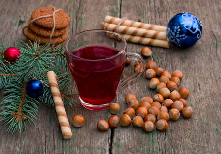 coniferous branch with Christmas tree decorations, tea, sweets and nutlets, the subject Christmas and New Yearの写真素材