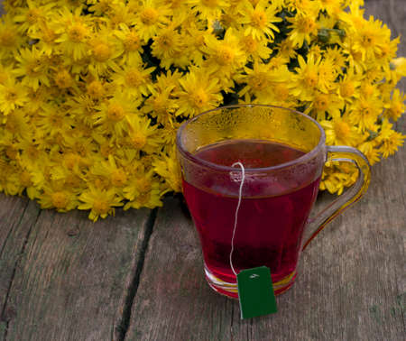 mug of black tea against a bouquet of yellow flowers, a subject drinks and flowersの写真素材