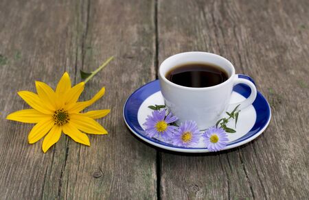 still life a cup of coffee and a yellow flower on a table, a subject flowers and seasonsの写真素材