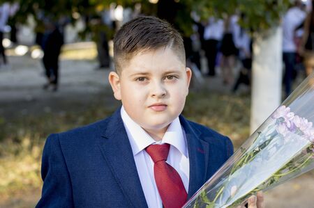 the school student in a claret tie with a bouquet, a subject school students, holidays, on September 1の写真素材