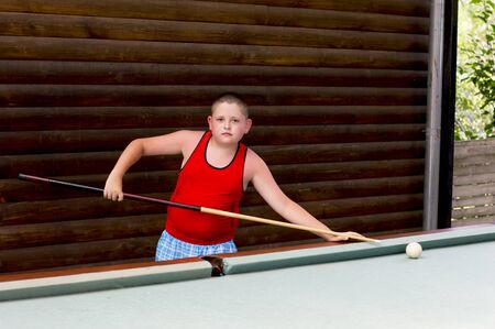 the boy plays billiards in the open air, a subject children, a game, entertainment, the resort
