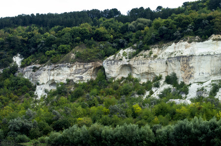 rocks are covered with trees near a river, the theme of the beautiful natureの写真素材