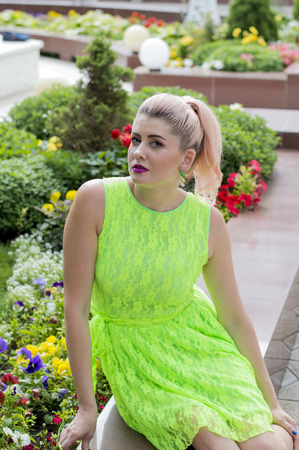 portrait of a girl crouched at the floral scenery, the theme of beautiful bright womenの写真素材