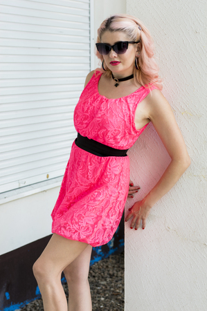 beautiful woman in pink dress at concrete pillar, beautiful bright women summer themeの写真素材