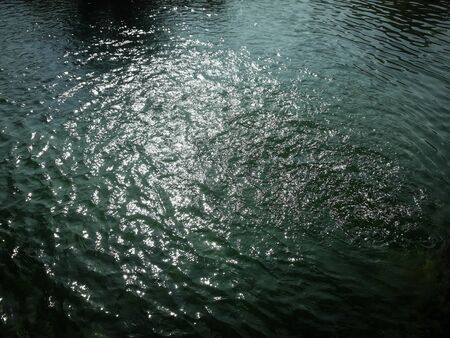 Wavy water surface in lake with greenish tonesの写真素材