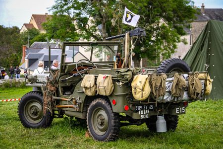 Image of an American army jeep in Normandy in a camp. Recreation on the 70th anniversary. Back view with tourists watchingのeditorial素材