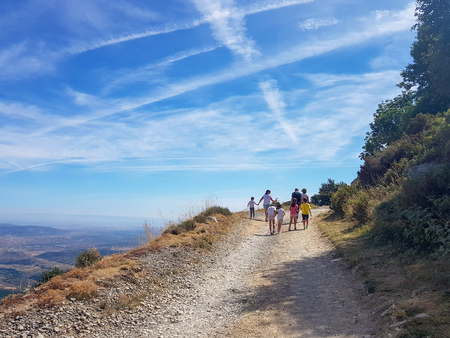 A group of people and children walking along a path. View from the back of models that are not recognizable.の写真素材
