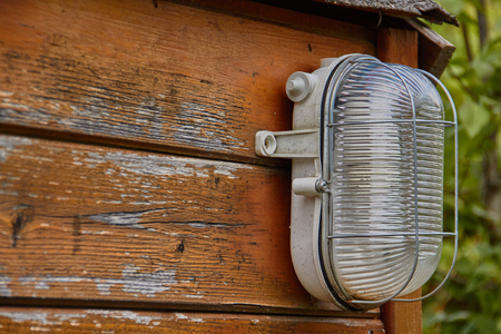 light lamp on the wall of a field cabin built in woodの写真素材