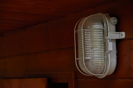 light lamp on the wall of a field cabin built in woodの写真素材