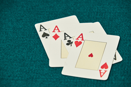 on the green table, a set of four aces stands out, to the right of the image leaving large space for inscriptions.の写真素材