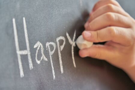 Graphical representation of the word, happy, written with chalk on blackboardの写真素材