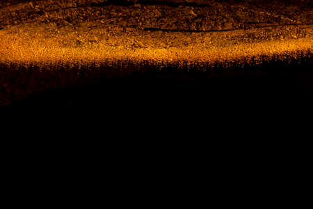 Abstract background of sand on a black background. Selective focus.