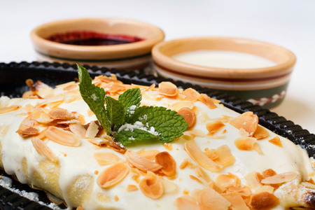 apple pie in vanilla frosting with sour cream and cherry jam on a white backgroundの写真素材