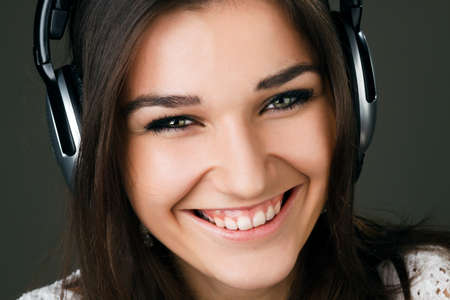 beautiful girl in headphones on a dark grey backgroundの写真素材
