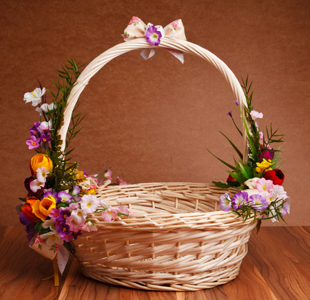basket decorated with flowers on wooden tableの写真素材