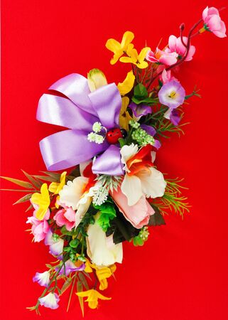 artificial flower arrangement on a red backgroundの写真素材