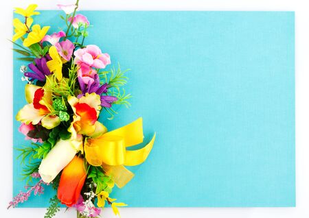 artificial flowers on blue background with place for labelの写真素材