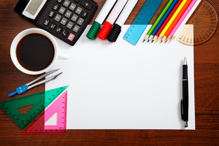 Desk with sheet of paper and stationery objects seen from aboveの写真素材