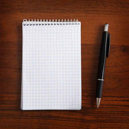 notebook and pen on a tableの写真素材