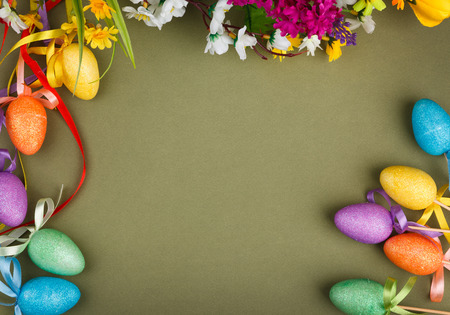 Easter flower arrangement and colorful eggs on green background with space for textの写真素材