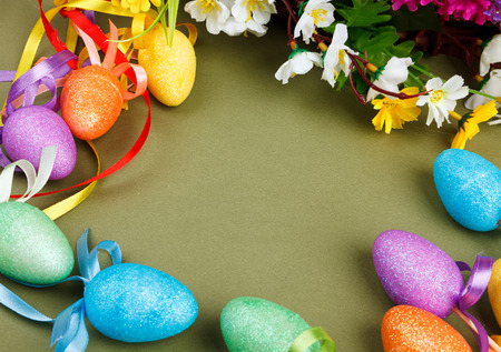 Easter flower arrangement and colorful eggs on green background with space for textの写真素材