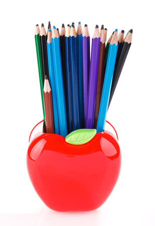 Colorful pencils in red apple shaped holder isolated on whiteの写真素材