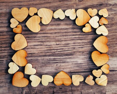 frame with hearts on a wooden background