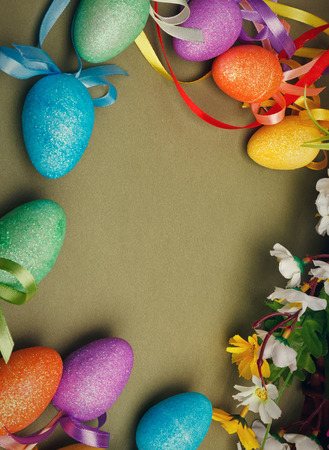 Easter flower arrangement and colorful eggs on green background with space for textの写真素材