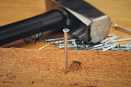 Hammer and nails on wooden boardの写真素材