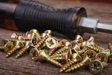 screwdriver and screws on wooden backgroundの写真素材