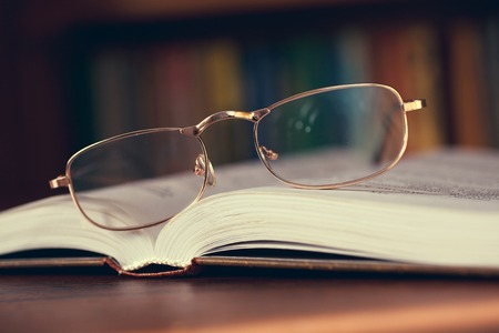glasses and book in the libraryの写真素材
