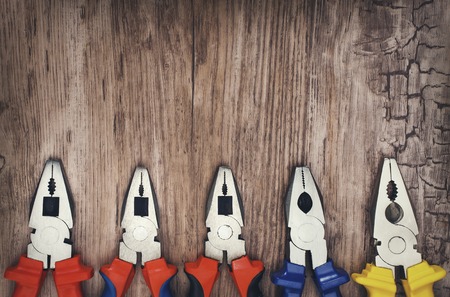 set of hand tools pliers on vintage wooden boardの写真素材