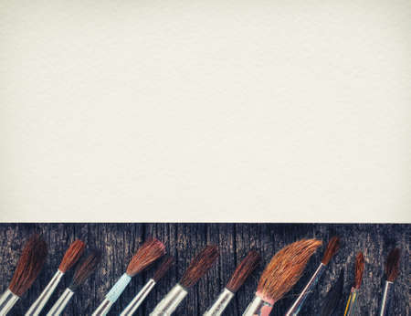 brushes for painting  and blank white paper sheet on vintage wooden  backgroundの写真素材