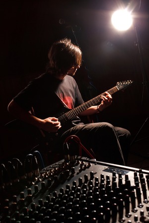 handsome guitarist recording and playing guitarの写真素材