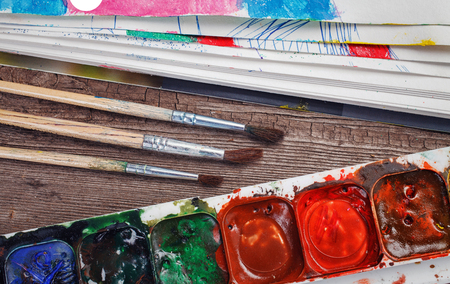 Paints and brushes on a wooden background closeupの写真素材