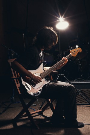 hairy guy playing bass guitarの写真素材