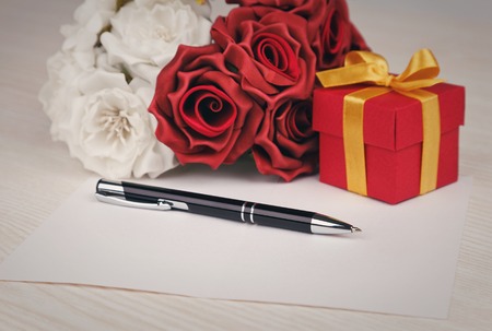 Greeting blank card with pen, rose and red box with yellow ribbonの写真素材