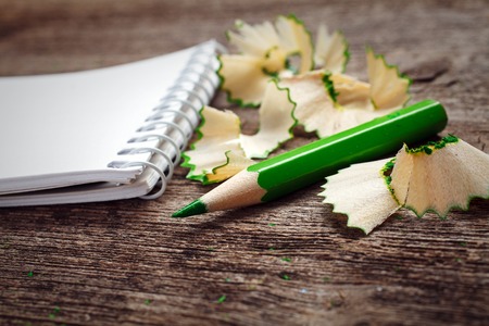 notebook with pensil and pencil shavings on wooden backgroundの写真素材