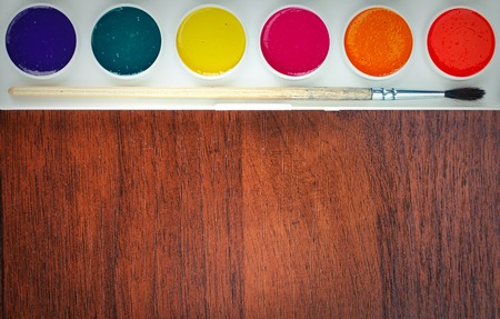 Colorful Aquarelle paints in a box and brushes on wooden backgroundの写真素材
