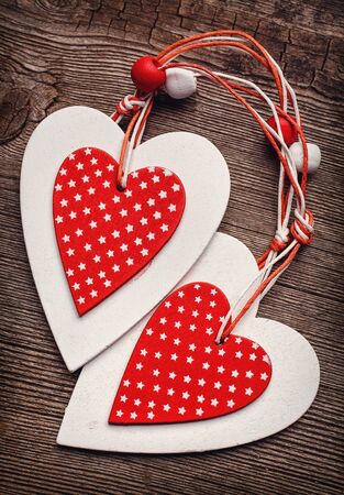 White and red sewed christmas hearts on wooden background, Holiday background for greetings Valentine's  dayの写真素材