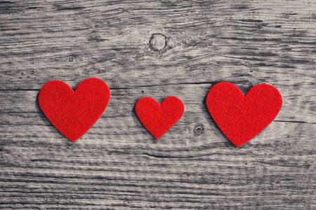 red hearts on a wooden surface backgroundの写真素材