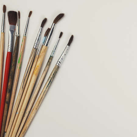 brushes for painting  and blank white paper sheet on vintage wooden  backgroundの写真素材