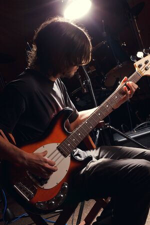 hairy guy playing bass guitarの写真素材