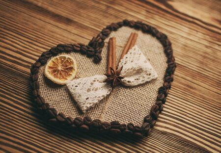 Love concept. decorated heart with coffee seeds on a wooden backgroundの写真素材