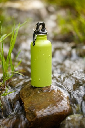 Camping steel thermos with water. Outdoor drinks item. Travel, tourism and camping equipment.の写真素材