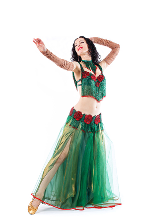 Beautiful Belly Dance girl in green baladi costume traditional egiptian dancing wear. Bellydancer artist dancing in studio. Arabic bellydance performer. Turkish female artistの写真素材